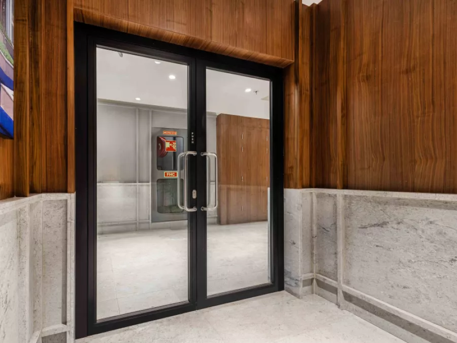 Brookfield_7 Fire-rated glass door, in a hallway with wood paneling and a light-colored floor.